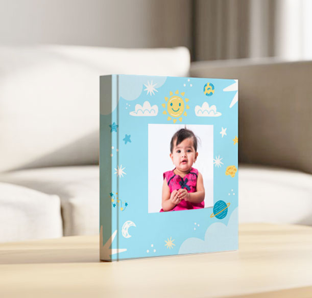 Variety of baby photo album sizes displayed on timber texture—great options for 1st birthday gifts for both boys and girls.